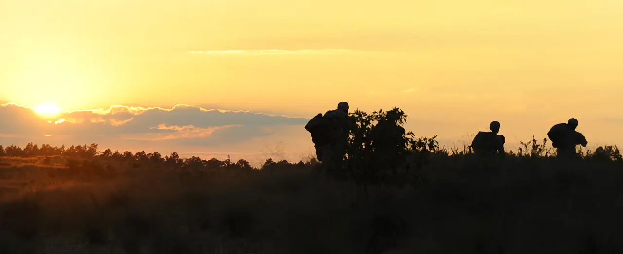 Service members silhouetted at sunset