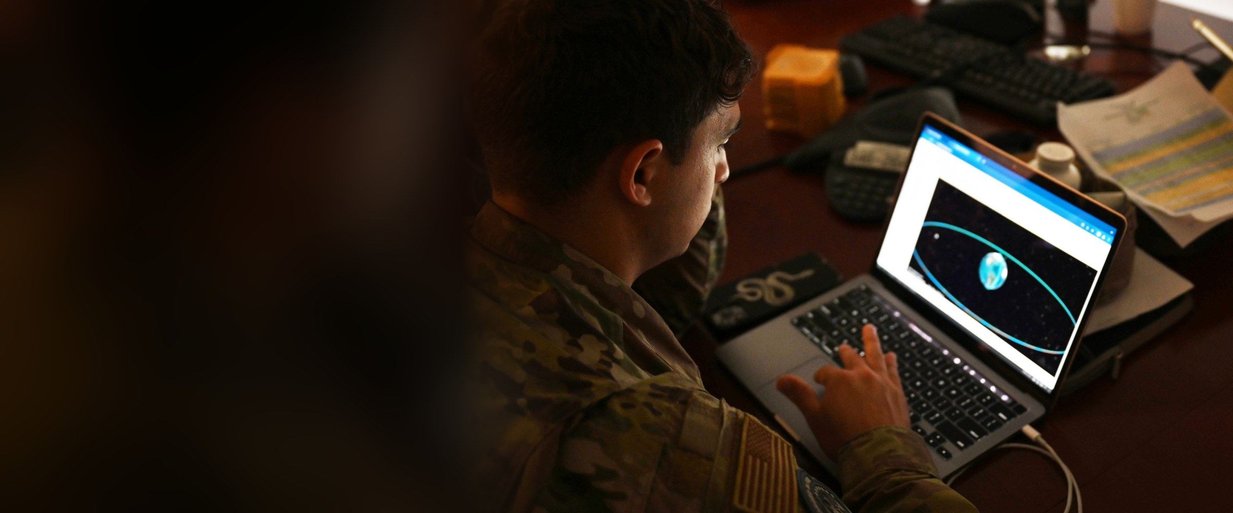 A U.S. Air Force Airman analyzing data on a laptop during a space-focused exercise